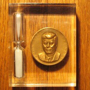 John F. Kennedy Coin and sand timer encapsulated in clear resin